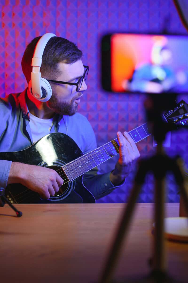 A musician recording a lesson on camera